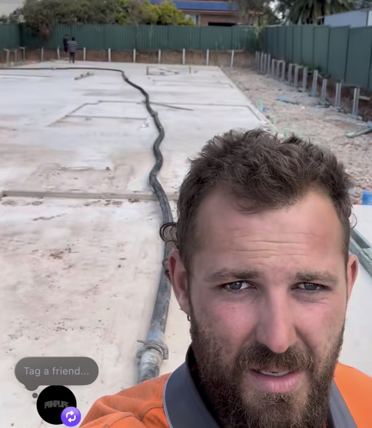 Operator on a freshly poured slab at Doonside, line hose running past.
